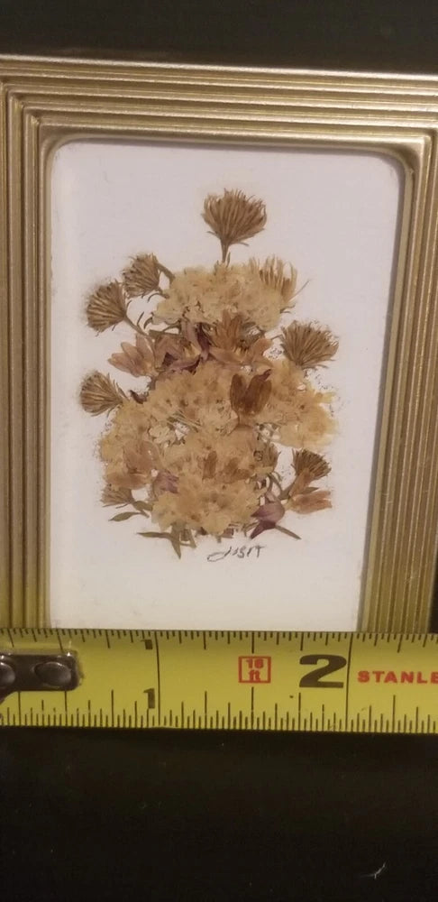 Small framed dried flower artwork with tan bouquet on light background, gold-tone frame