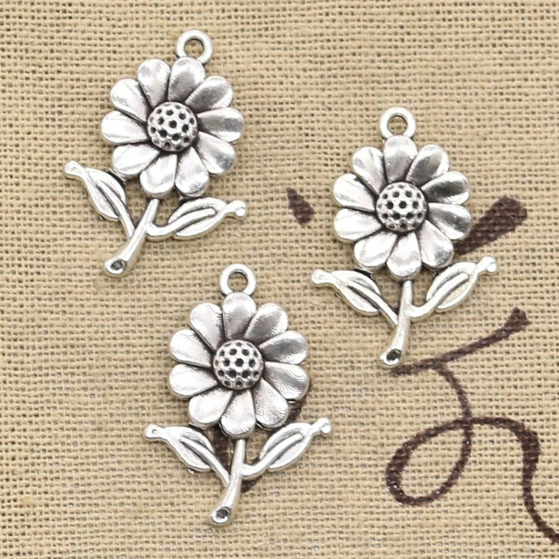 Antique silver sunflower pendant charms, each with top loop and small leaf detail