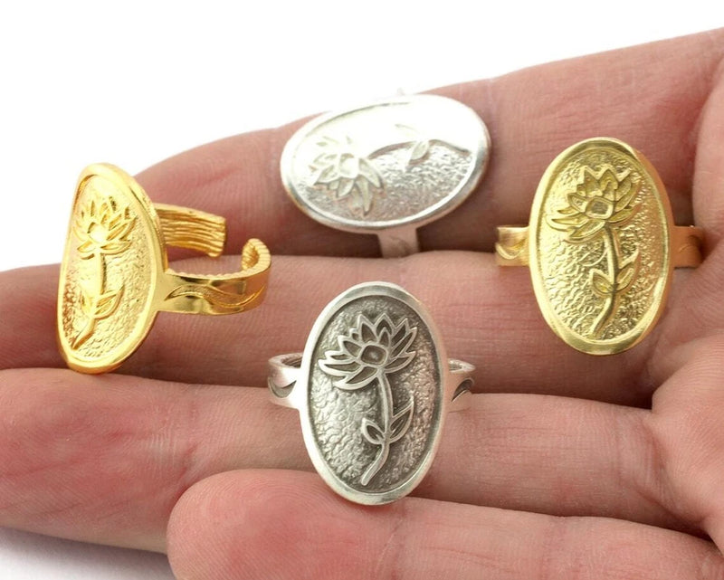 Adjustable brass ring with engraved water lily motif, oval face, gold and silver tones