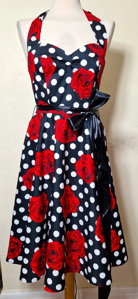 Halter neck dress in black with white polka dots and red rose print, tied waist