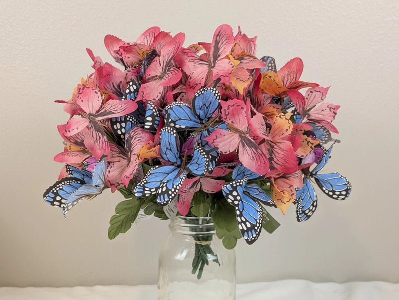 Artificial butterfly floral pick bouquet with pink and blue butterflies and green leaves stems
