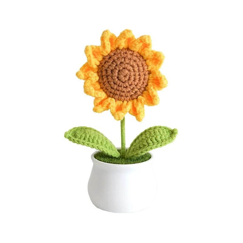 Crocheted sunflower decor with orange-yellow petals, brown center, green leaves in white pot
