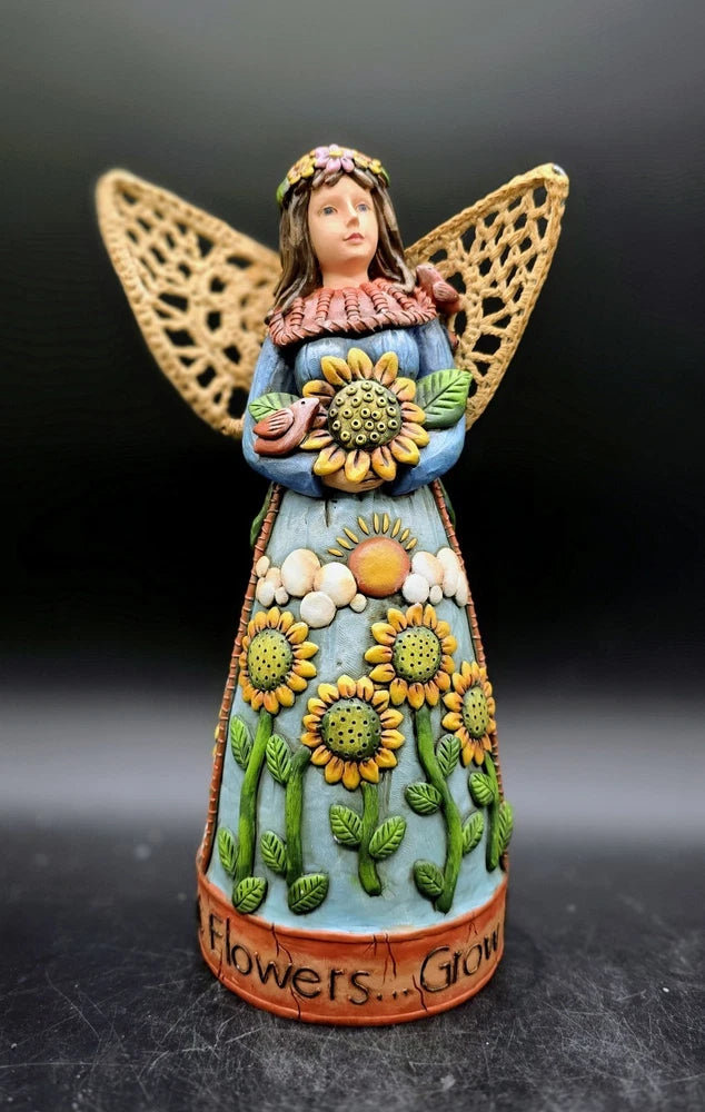 Sunflower-themed angel figurine holding flowers, painted dress with yellow blooms