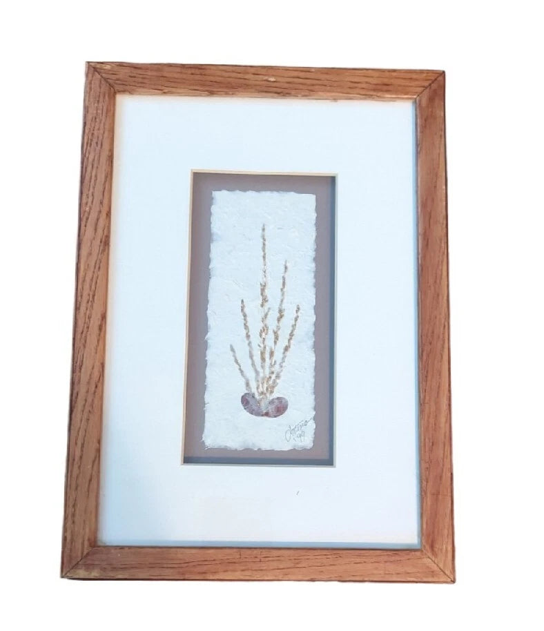 Framed dried pressed flower wall art with small vertical sprig in light mat, wood frame