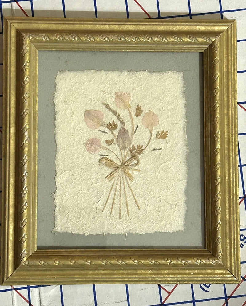 Framed pressed dried flower bouquet on off-white paper, gold ornate picture frame