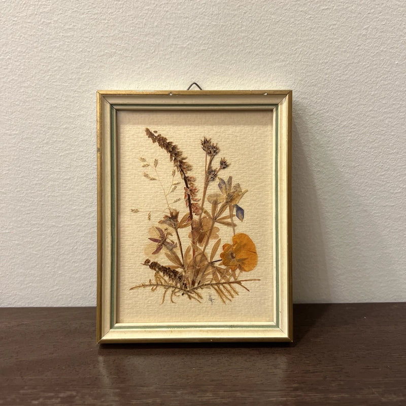 Framed pressed flower botanical artwork with dried wildflowers, square gold-toned frame