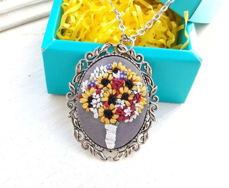 Embroidered sunflower pendant necklace with silver-tone filigree oval and chain