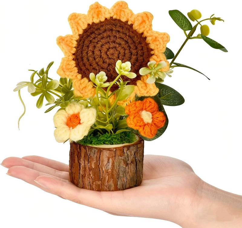 Crochet sunflower bouquet in small wooden pot with orange petals, green leaves, white blooms