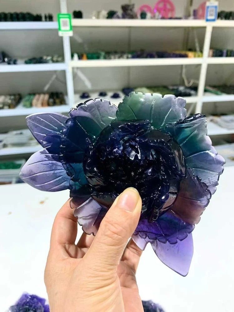 Carved fluorite quartz skull surrounded by purple and teal peony petals, crystal decor