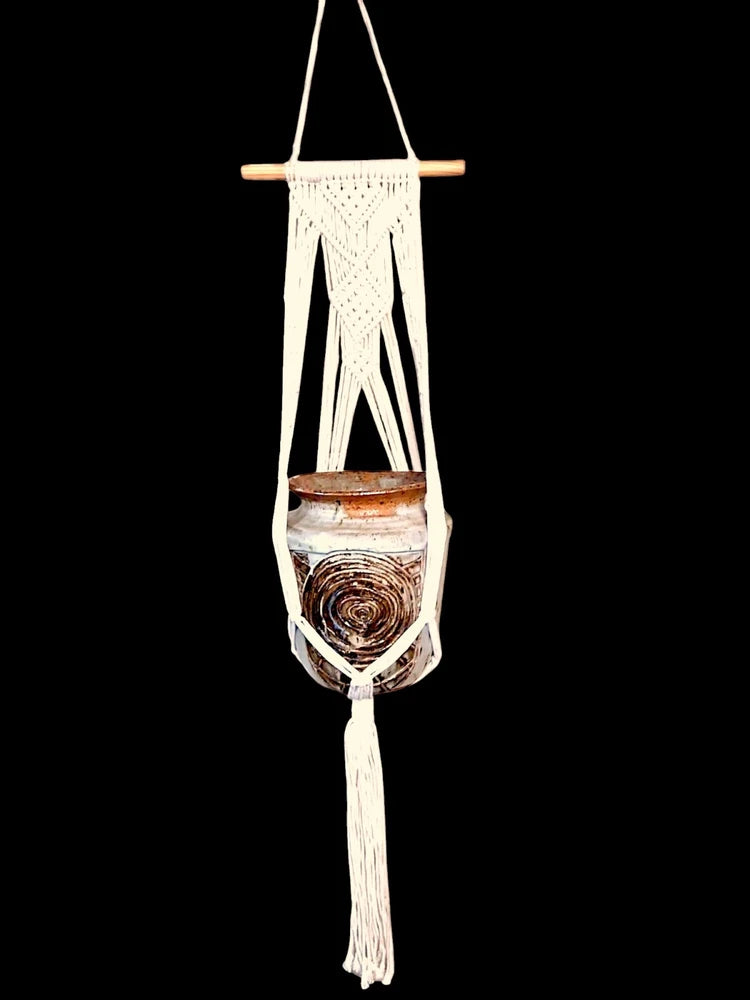 White macrame plant pot hanger with tassels and stoneware pot