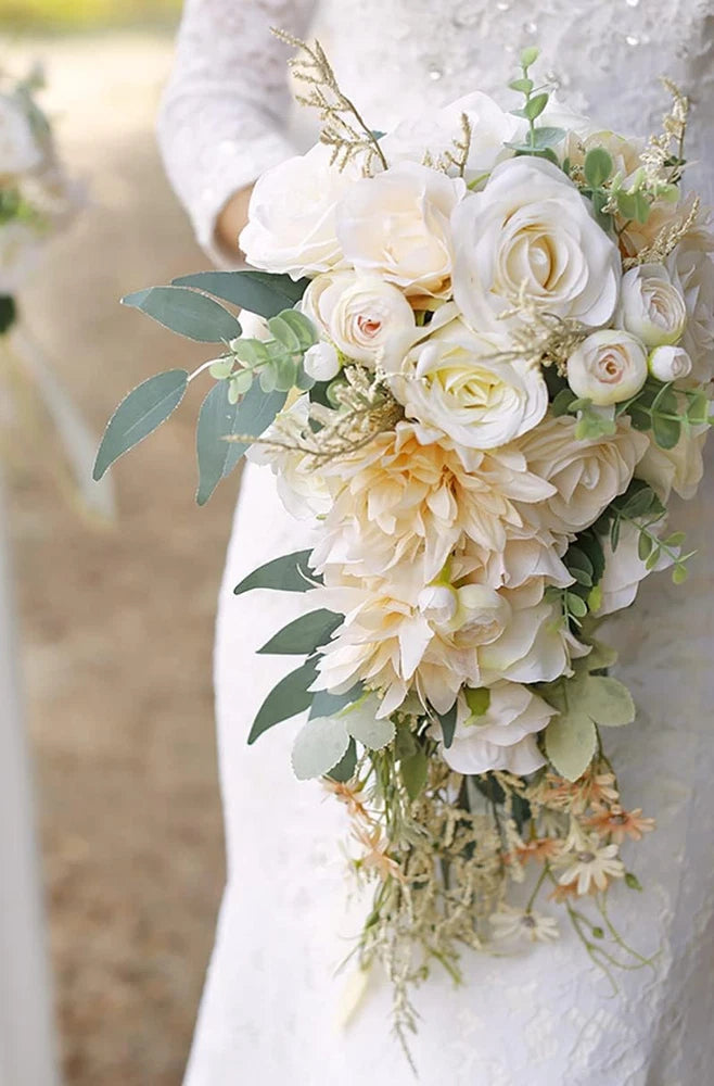 Cascading bridal bouquet of white and cream roses with beige accents and greenery