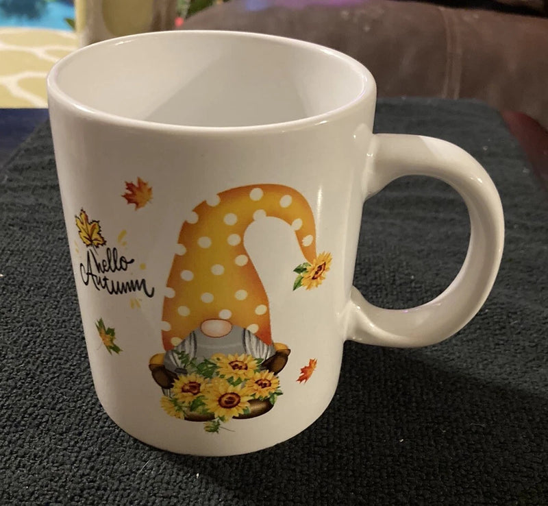 White ceramic coffee mug with Hello Autumn text, sunflower bouquet and leaf decorations