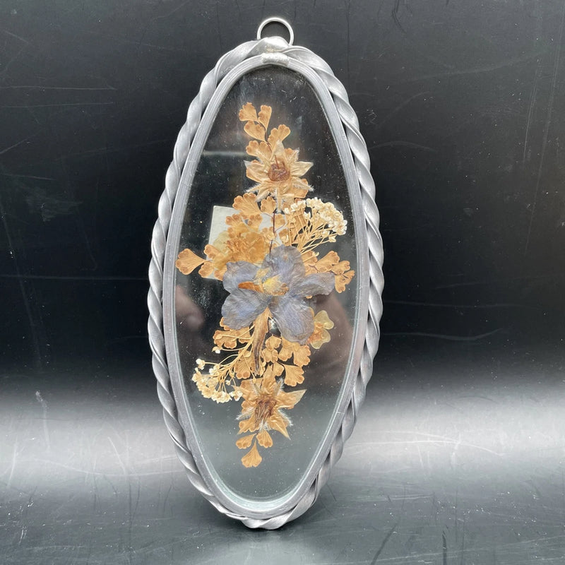 Oval glass pressed dried flowers in silver braided frame