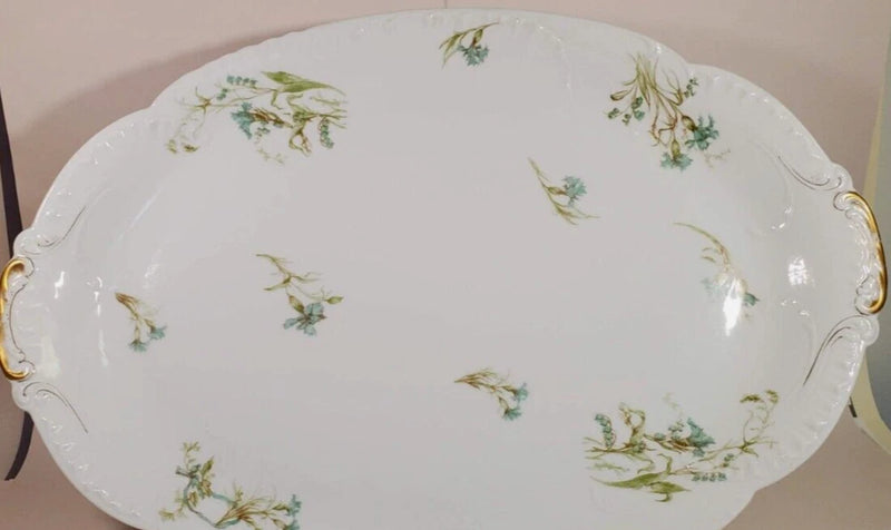 Antique oval ceramic platter with scattered green and turquoise floral sprigs