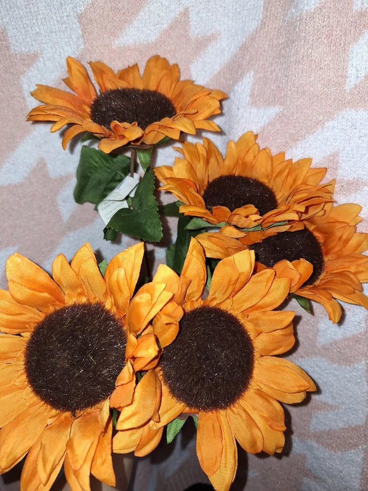 Orange sunflower bunch with dark centers and green leaves