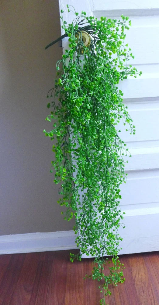 Green artificial hanging rattan cane plant with cascading foliage stems