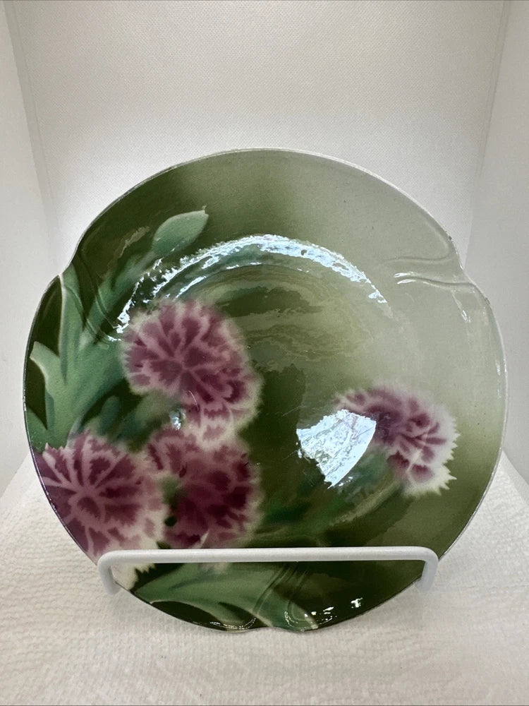 Vintage green ceramic plate with purple carnation floral design and scalloped rim