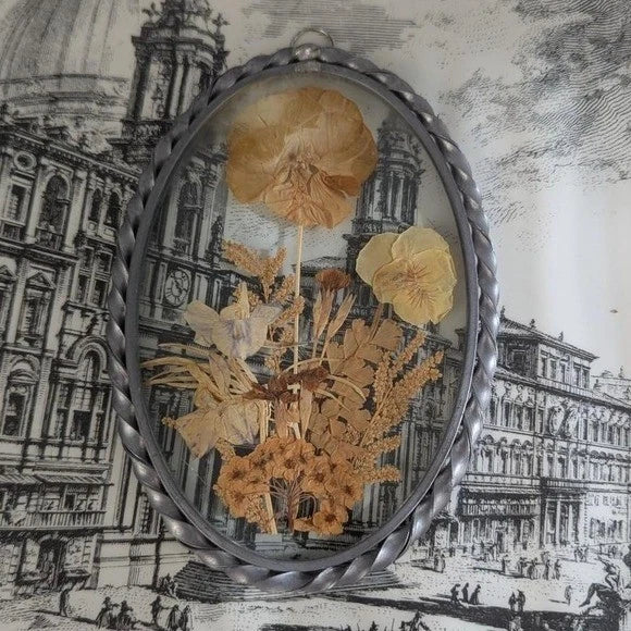 Oval pressed flower wall art with convex glass and silver braided frame