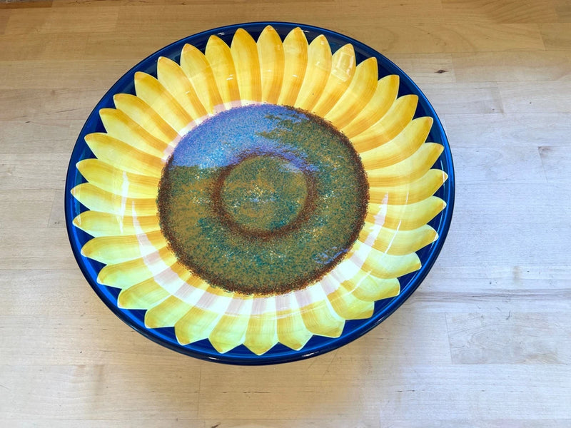 Blue serving bowl with yellow sunflower design and green center