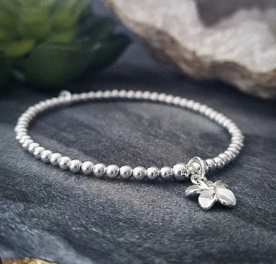 Sterling silver beaded stretch bracelet with small lily flower charm