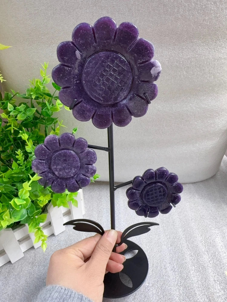 Purple carved crystal sunflower flowers on black stand, three blooms visible