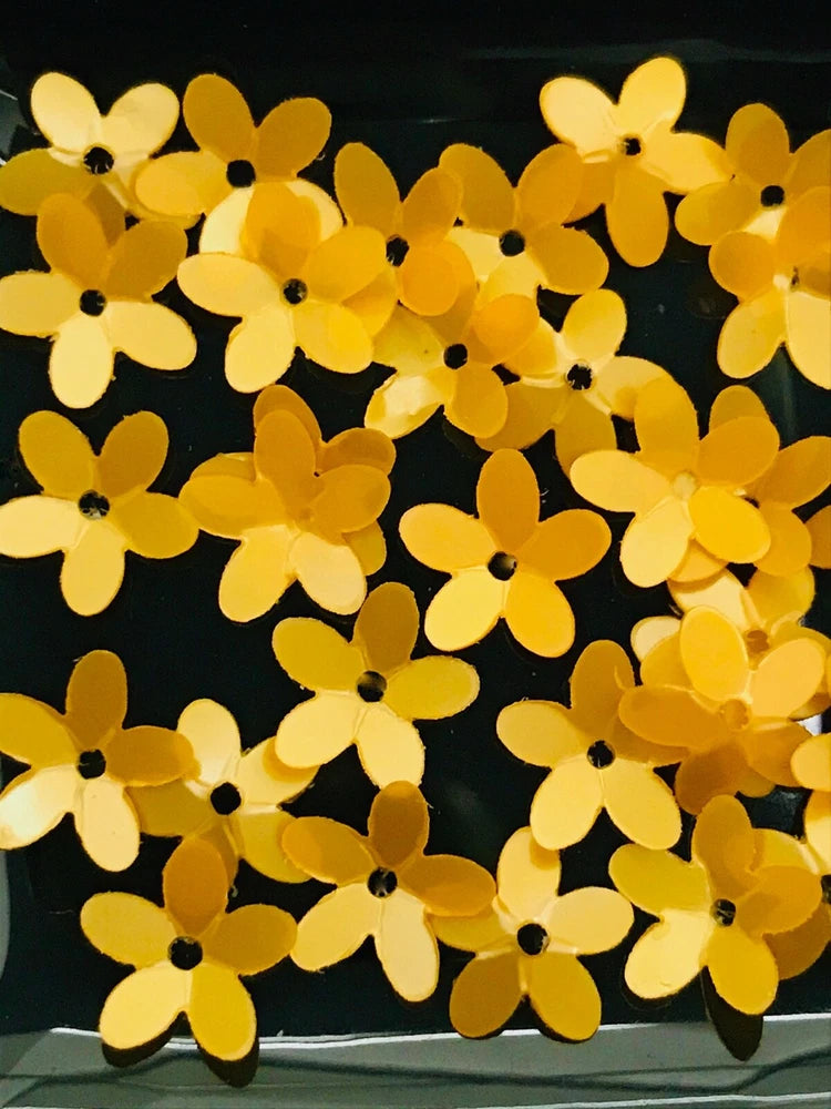 Golden yellow flower-shaped sequin appliques with small black centers, shiny