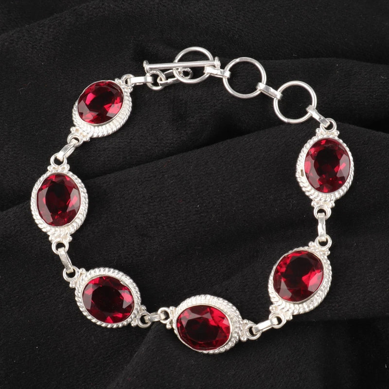925 sterling silver gemstone bracelet with red oval cut stones in silver settings