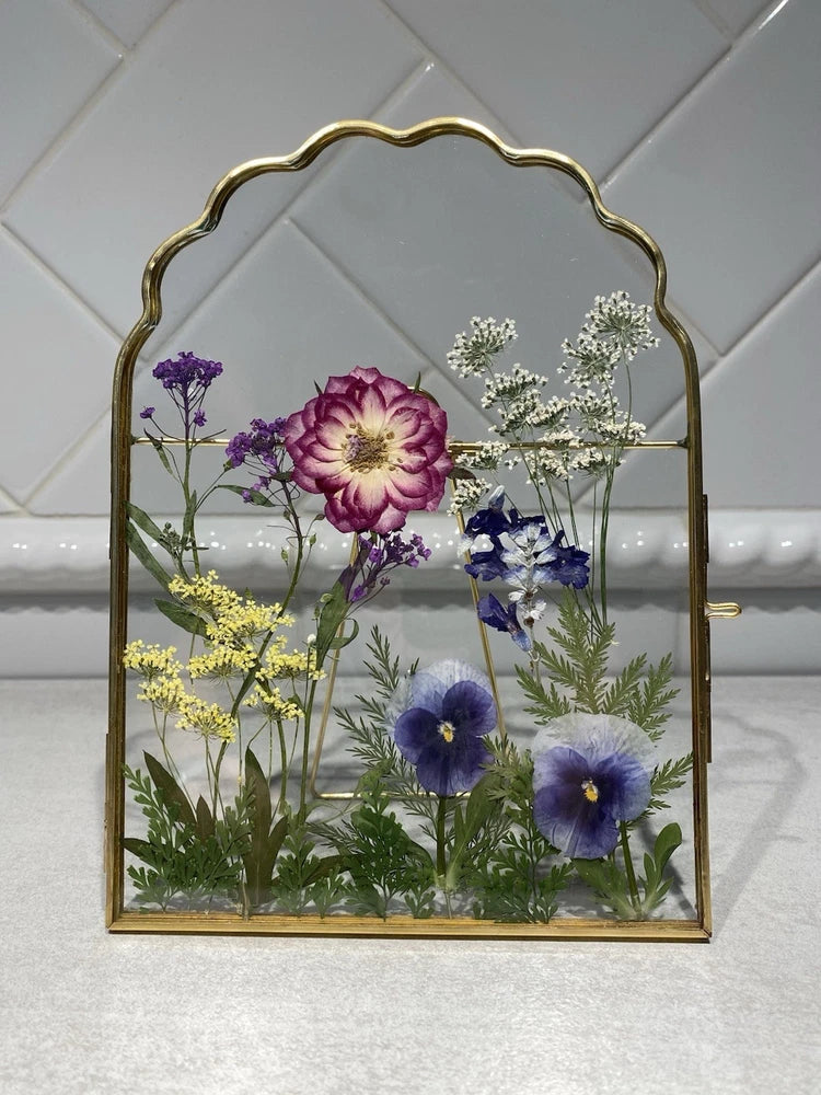 Arched gold glass floating frame with mixed pressed dried flowers in pink, purple, yellow