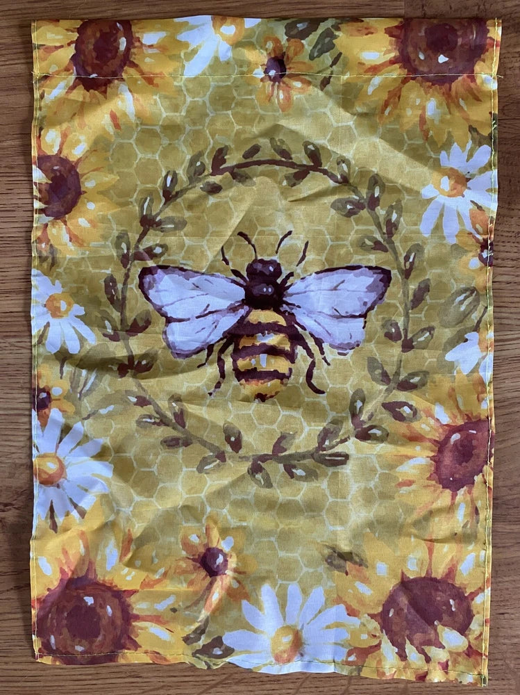Garden flag with central bee illustration on honeycomb and sunflower pattern