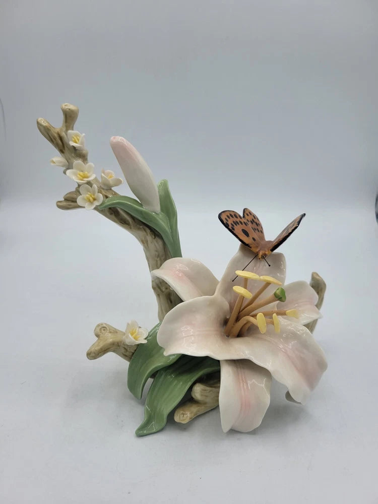 Hand-painted ceramic figurine with white lilies and a brown butterfly