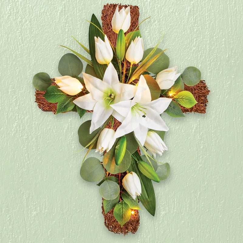 LED lighted flower cross wall hanging with white lilies, green leaves, warm lights