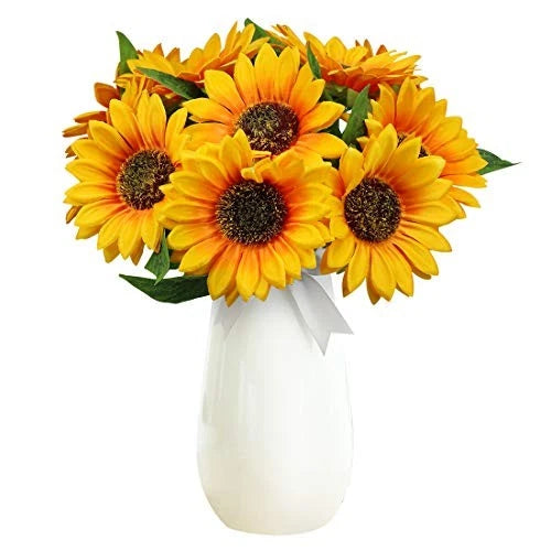 Artificial yellow sunflower stems bouquet in white vase with dark brown centers and green leaves