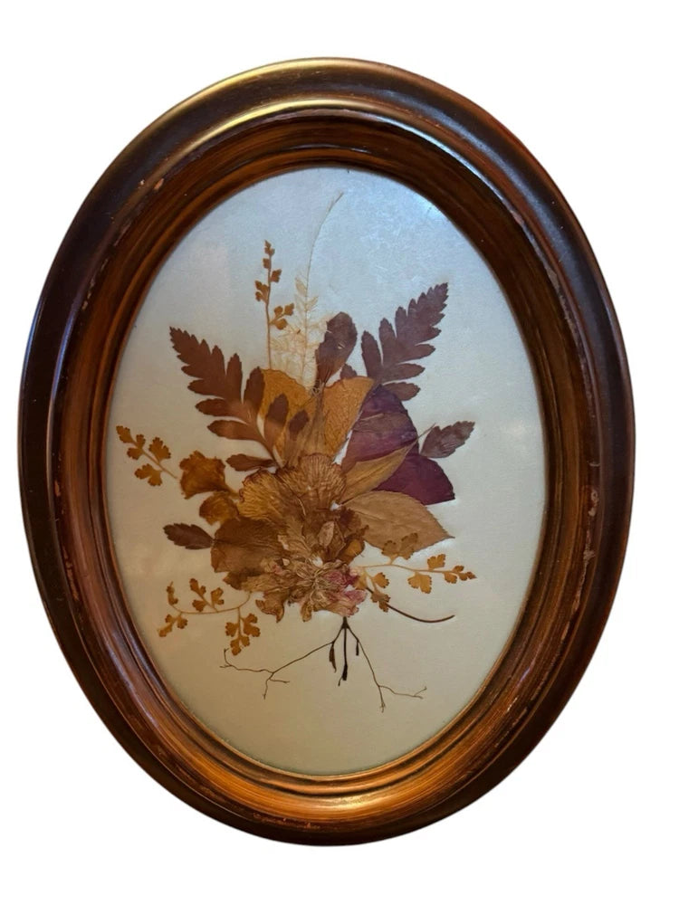 Vintage pressed flower oval framed art with dried bouquet inside dark brown frame