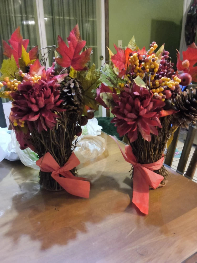 Rustic autumn floral arrangement set with twig bases, burgundy blooms, pinecones, and pink bows (2)