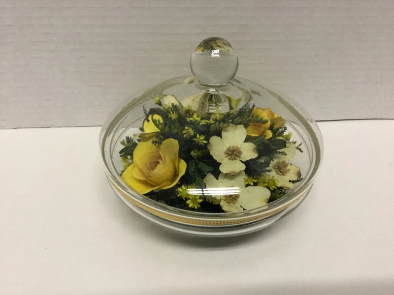 Glass apothecary jar with faux dried yellow and green flowers, round lid
