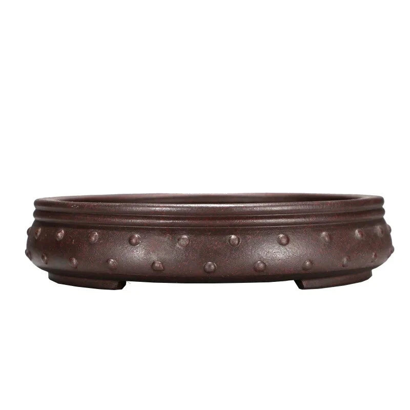 Brown ceramic bonsai pot with raised stud pattern and low round bowl shape