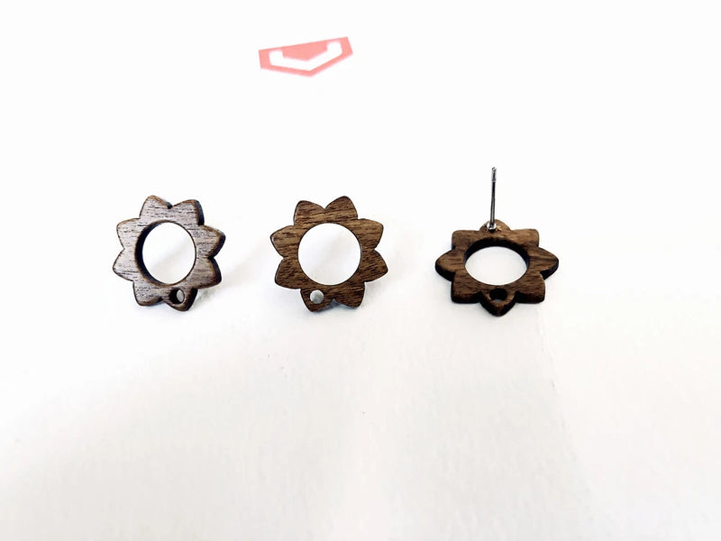 Wooden flower-shaped stud earrings with round white insets, brown and light tones.