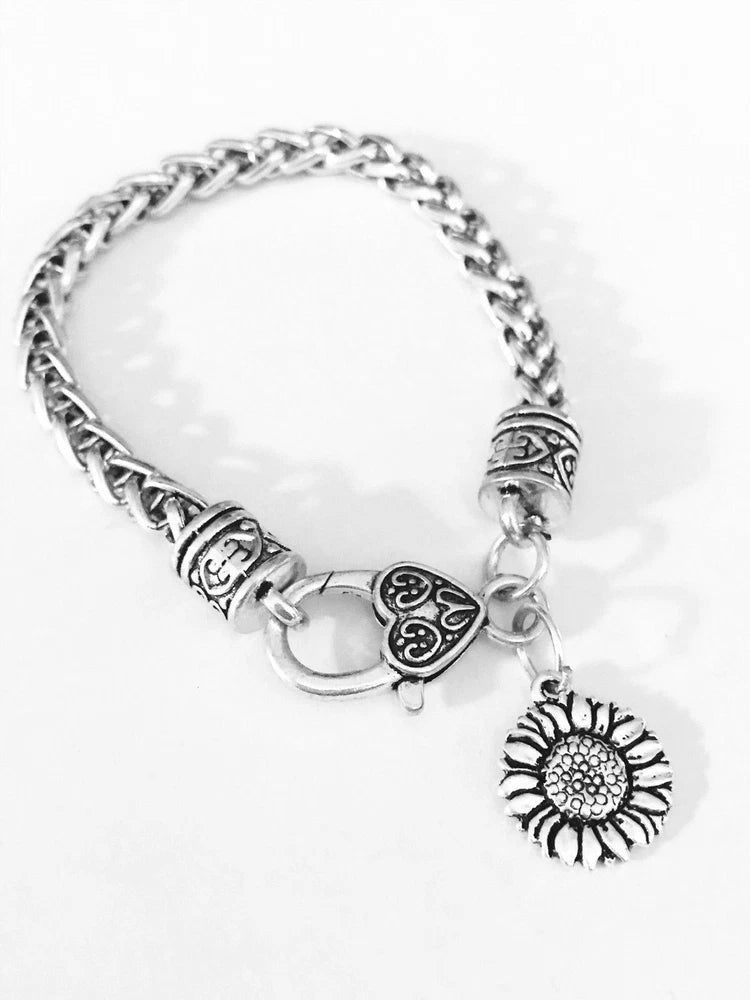 Silver-tone charm bracelet with sunflower pendant, heart bead, and round clasp charm
