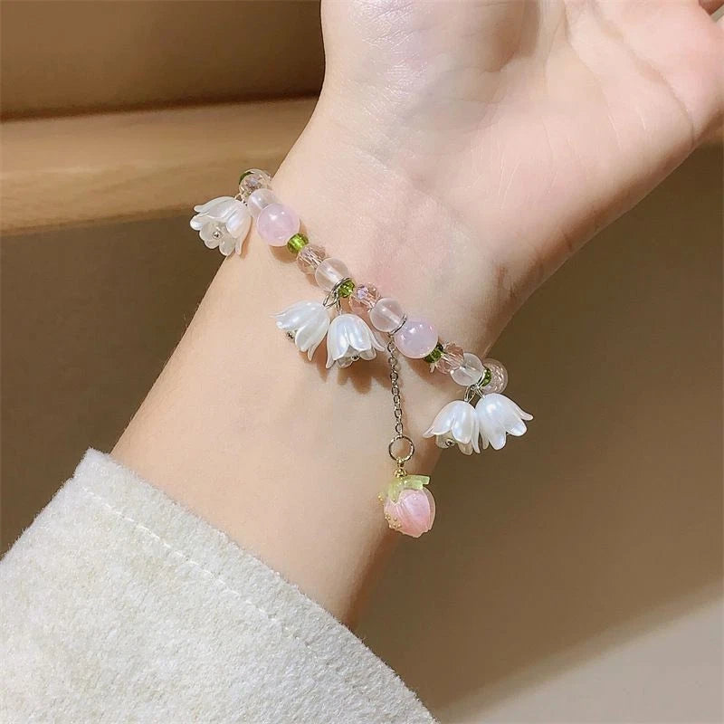 Pink beaded bracelet with white lily flower charms and small pink drop beads