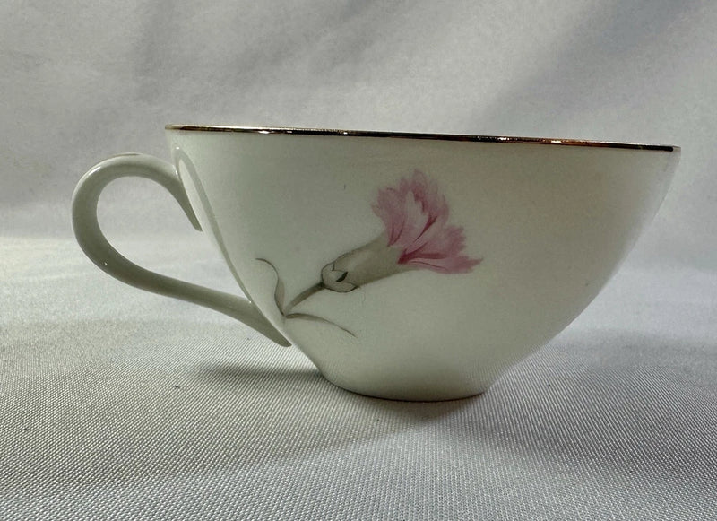 Porcelain tea cup with pink carnation flowers, gold-trimmed rim, and side handle