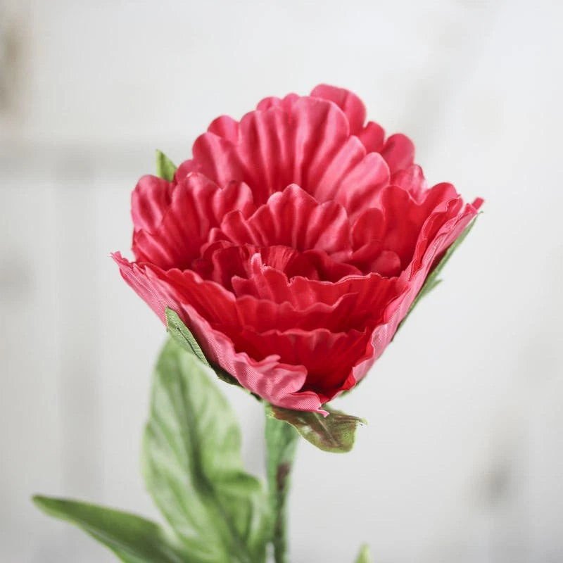Pink artificial polyester peony floral stem with layered petals on a green stem