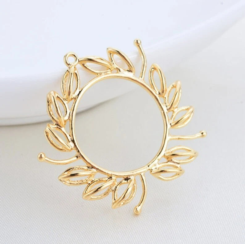 Gold-tone sunflower pendant charm with ornate petals, leaf accents, and top hanging loop