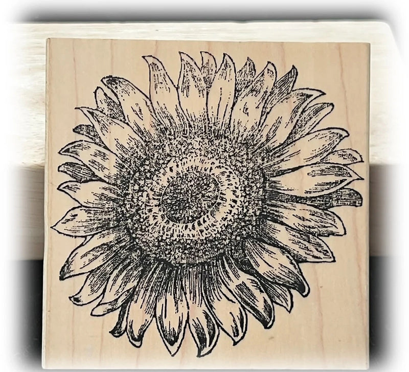 Wood-mounted rubber stamp with black sunflower line-art on a wooden block
