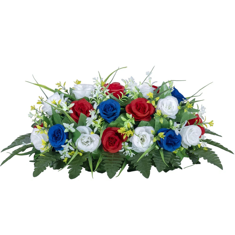 Floral tombstone saddle with red, blue, and white roses and greenery.