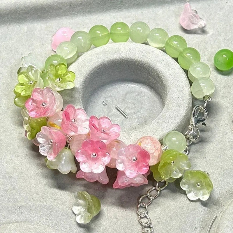 Beaded flower bracelet with translucent green and pink lily charms and silver-tone chain links
