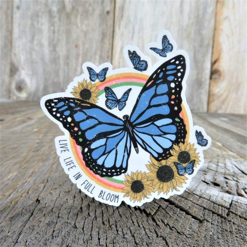 Sunflower and butterfly sticker with blue butterflies and curved text: LIVE LIFE IN FULL BLOOM