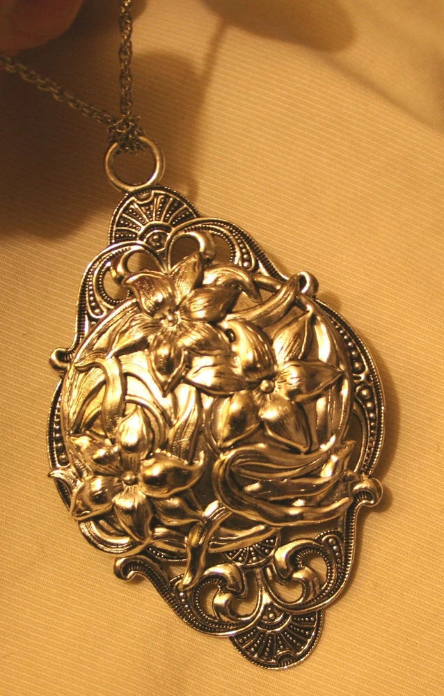 Silvertone filigree pendant necklace with raised lily flower cluster