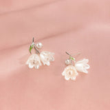 Sterling silver lily flower drop earrings with white pearl center and green leaf accents