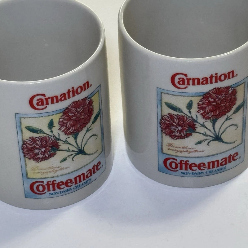 Pair of white ceramic coffee mugs with red floral Carnation Coffee-mate logos