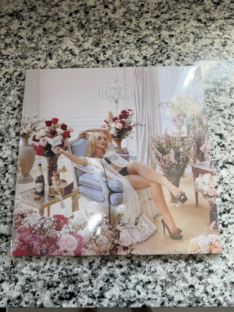 Pink champagne vinyl LP cover with woman seated in floral garden scene